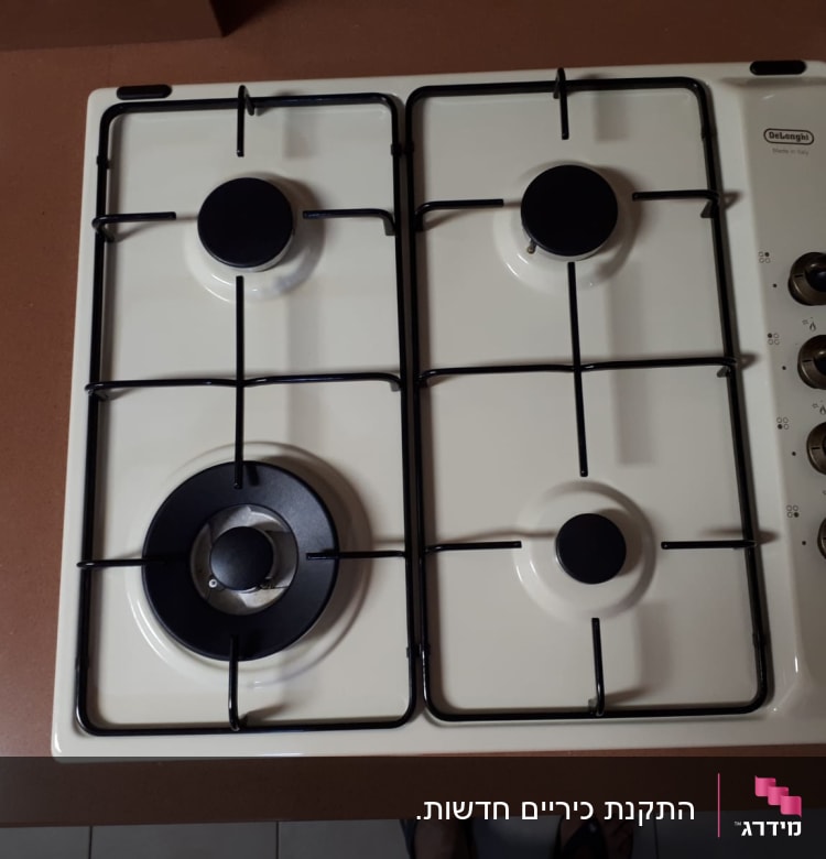 כיריים גז לבנים עם ארבעה מבערים וכפתורי שליטה
